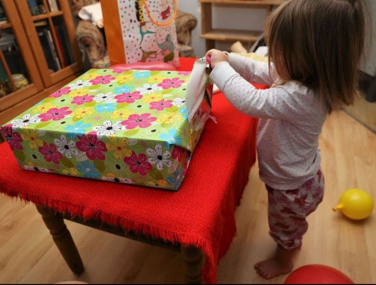 Toddler Girl unwrapping Birthday Presents